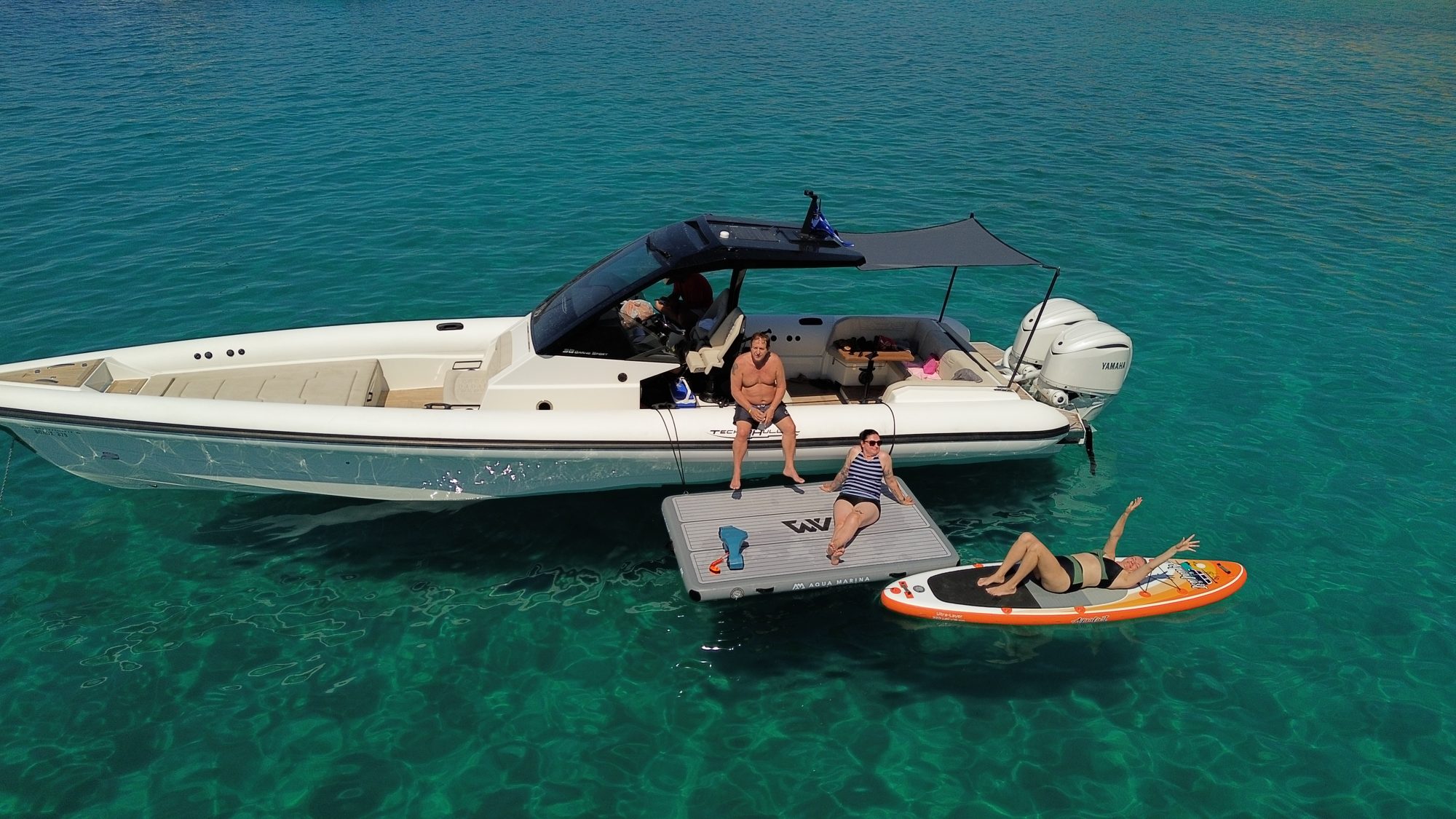 Guests relaxing beside a Technohull boat on the water
