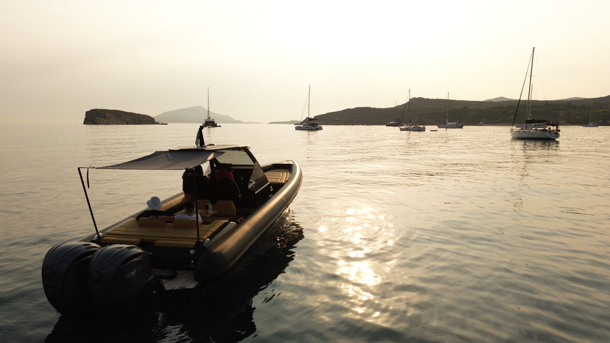 Technohull boat on calm water at sunset